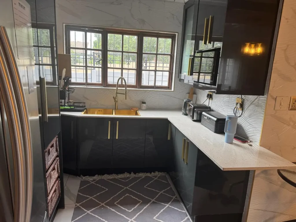 Modern black kitchen cupboards with quartz countertops installed by a carpenter in Kempton Park, featuring custom cabinetry, built-in storage, and clean finishes