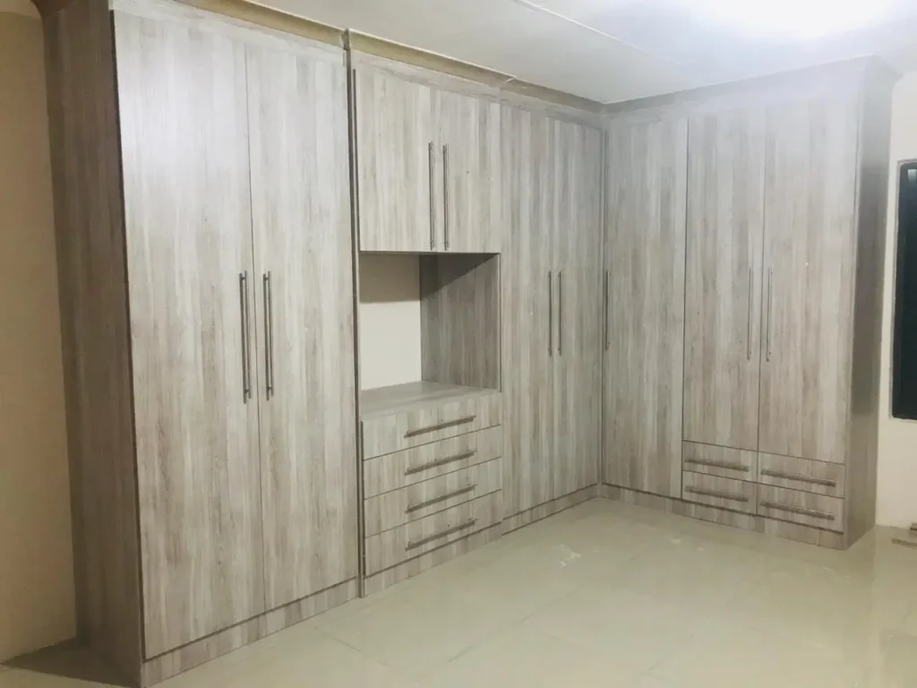 Wardrobe installation showing fitted built in cupboards with full height doors and drawer storage in a modern bedroom